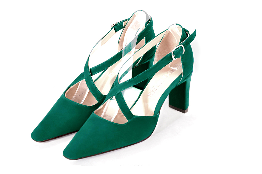 Emerald green open side elegant shoes, with crossed straps. Tapered toe. High comma heels.